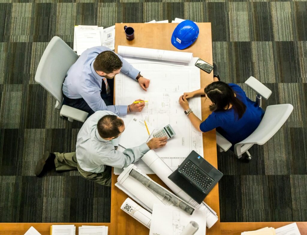 Top view of a team working on construction plans in an office setting.